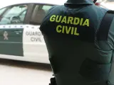 05/06/2022 Un agente de la Guardia Civil, de espaldas, junto a un vehículo oficial SOCIEDAD GUARDIA CIVIL