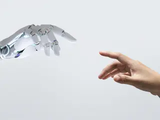 Una mano robot toca una mano humana
