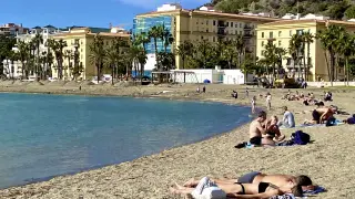 Varias personas disfrutan este domingo en bañador del buen tiempo en la playa de La Malagueta de Málaga.