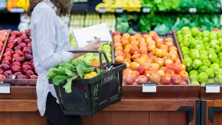 Una mujer comprando frutas y verduras.
