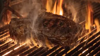 Pieza de carne haciéndose a la parrilla.